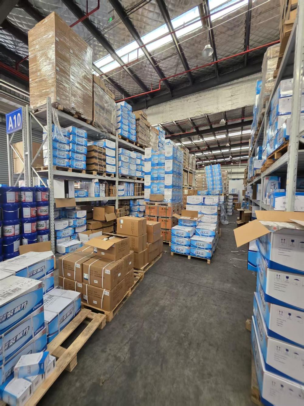 Bulk stacked engine parts cartons in warehouse aisle